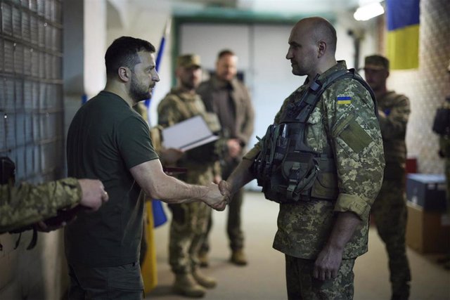 Ukrainian President Volodimir Zelensky greets a soldier at the Donetsk front.
