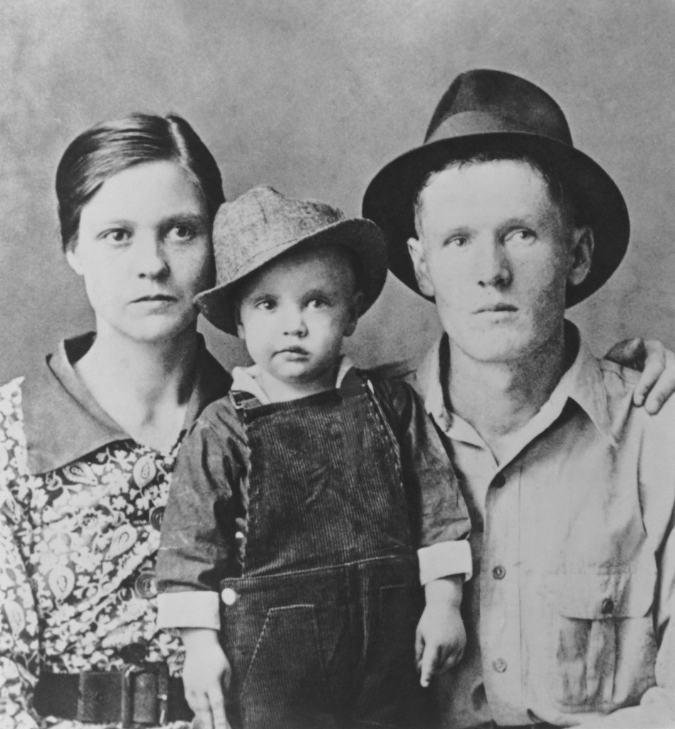 Two-year-old Elvis Presley poses for a family portrait with his parents Vernon Presley and Gladys Presley in 1937 in Tupelo, Mississippi.