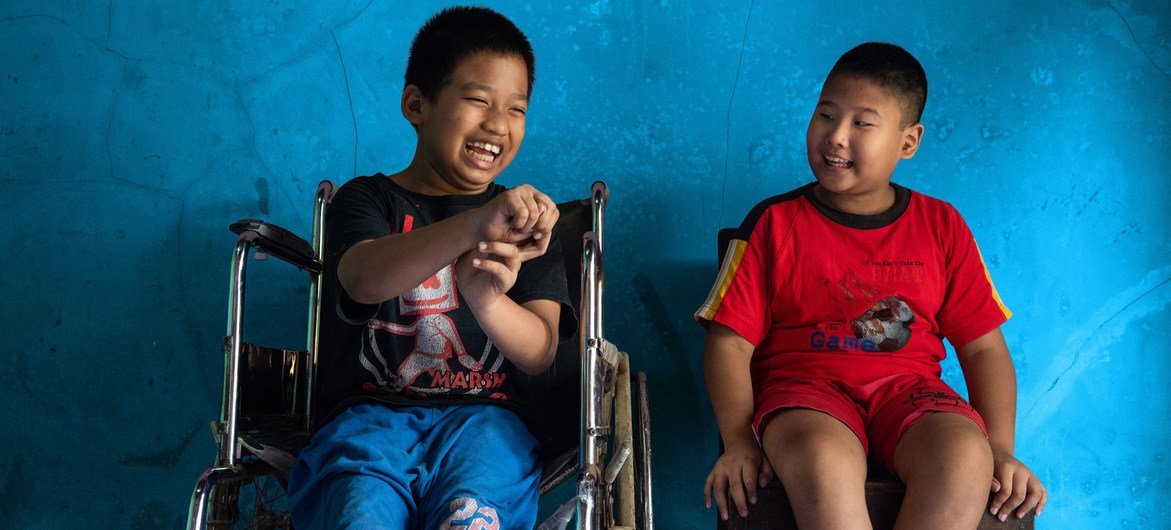 A boy (left) with a physical disability sits next to his best friend who is visually impaired, in Banyumas, Central Java, Indonesia.