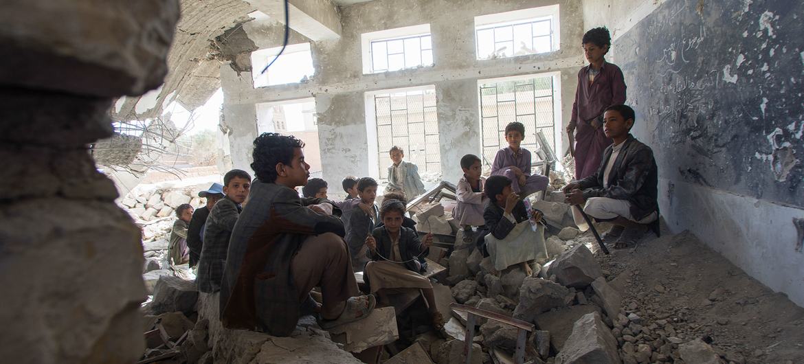 Children sit in an old classroom of a destroyed school in the city of Saada, Yemen.  They now attend school in UNICEF tents.