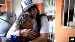 María Eva Noble, who is part of the social movement "Avoid Movement" (wearing a cap), hugs another volunteer at a soup kitchen in Buenos Aires, Argentina, on July 26, 2022, the day of the 70th anniversary of the death of Argentina's most famous first lady, Eva Perón, who died at cause of cancer on July 26, 1952, at the age of 33.  (AP Photo/Natacha Pisarenko)