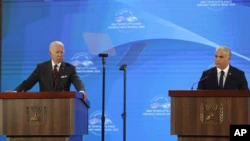 US President Joe Biden, left, gives a news conference with Israeli Prime Minister Yair Lapid at the Waldorf Astoria hotel in Jerusalem, Thursday, July 14, 2022. (Atef Safadi/Pool via P.A.)