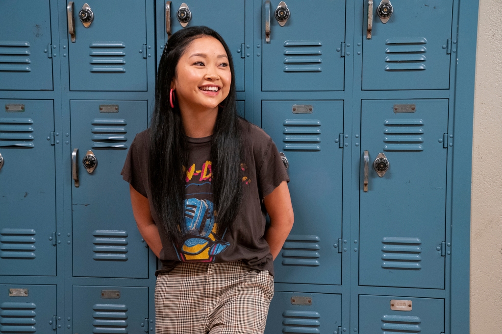 Lana Condor smiles and leans against the lockers.