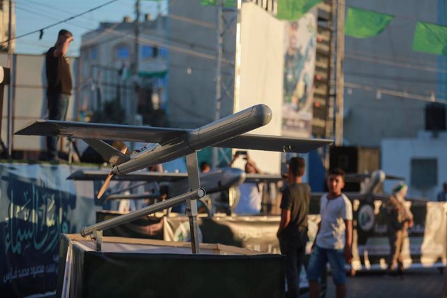 26 July 2022, Palestinian Territories, Khan Younis: People stand near a group of A1b drones made by Hamas, which were used in the 2014 and 2021 wars between Gaza and Israel