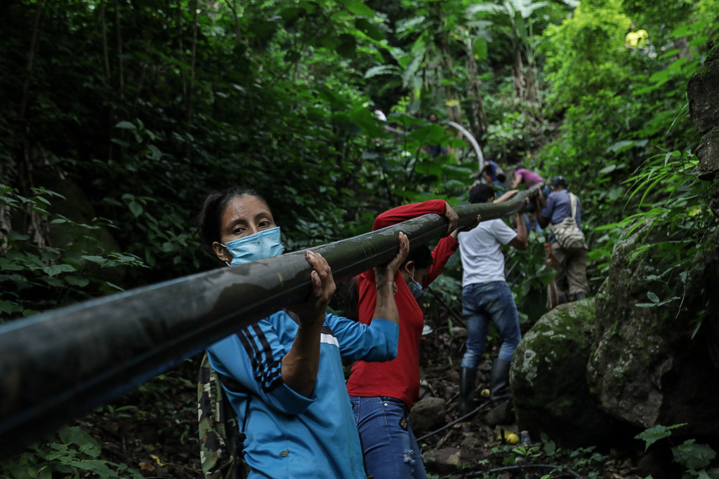 Yarledys Olaya (left) works with other ex-combatants and local people to build a water pipeline.