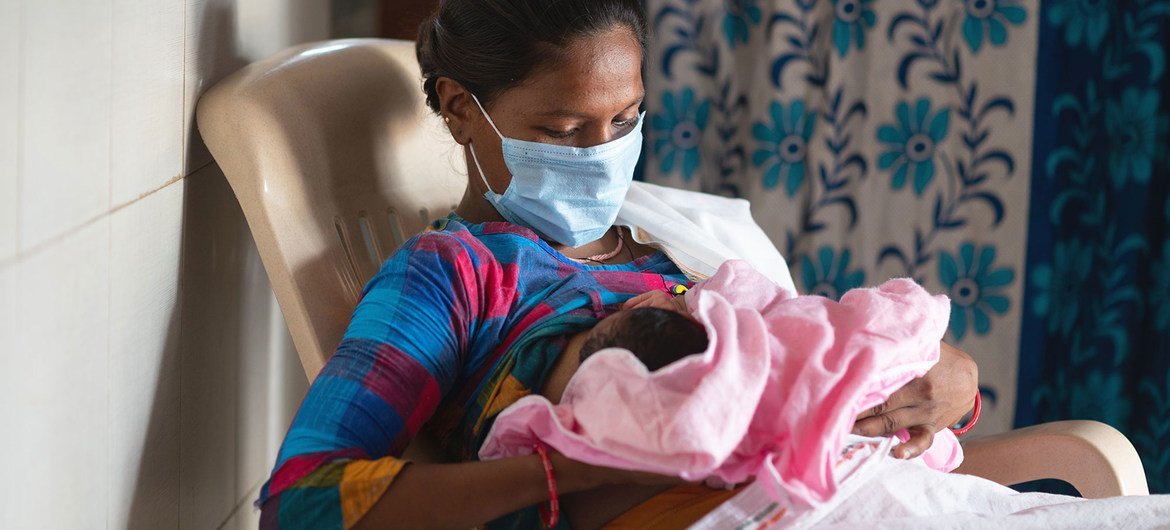 A woman breastfeeds her baby in a delivery room in India shortly after giving birth.