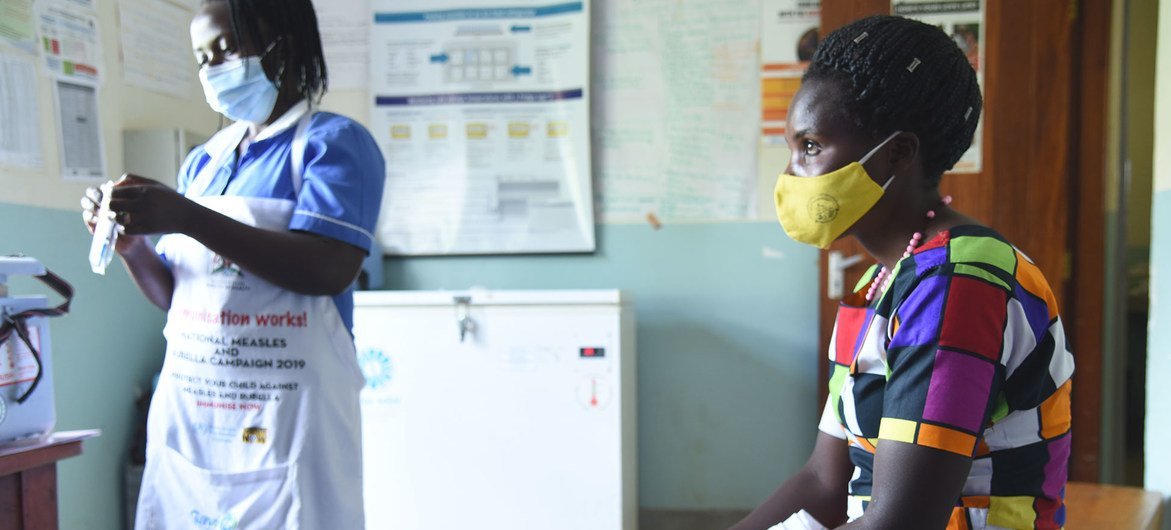 A nurse prepares to administer a COVID-19 vaccine to a patient at a Kabale health center in Uganda.