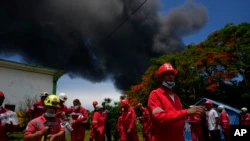 Members of the Cuban Red Cross prepare to be transported to the Matanzas Super Tanker Base, where firefighters work to put out a fire that started during a thunderstorm the night before, in Matazanas, Cuba, Saturday, August 6, 2022. The fire got out of control on Saturday.  Four explosions and flames injured dozens of people and left more than a dozen firefighters missing, Cuban authorities said.  (AP Photo/Ramon Espinosa)