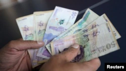 An employee counts Colombian pesos at a store in Bogota, Colombia, on December 28, 2018.