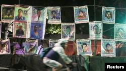 A person walks past a wall with photos of some of the 43 students who disappeared from the Ayotzinapa Rural Teachers College.  Taken in Mexico City, on August 19, 2022.