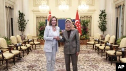 In this photo provided by Singapore's Ministry of Communications and Information, US House Speaker Nancy Pelosi, left, and Singaporean President Halimah Yacob shake hands at the Presidential Palace of Istana in Singapore, on Monday, August 1, 2022.