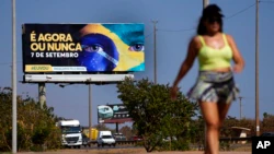 A billboard rises above a jogging trail with a message in Portuguese that reads; "It's now or never, September 7"in support of President Jair Bolsonaro's call for his supporters to join the bicentennial celebrations, in Brasilia, Brazil, Tuesday, Sept. 6, 2022. Brazil celebrates the bicentennial of its independence on Wednesday, Sept. 7. (AP Photo / Eraldo Peres)