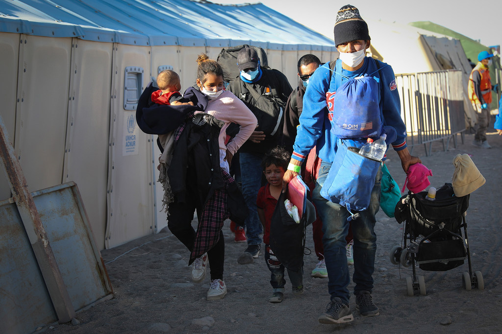 Jhonny, 26, Cribsel, 19, and their two children arrive at a migrant refugee center in Colchane.