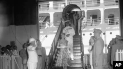 Panamanian authorities receive with honors Queen Elizabeth II and Prince Philip upon their arrival at the Panama Canal on November 29, 1953. It was the first visit of the nomarch to American territory.  Officials and diplomats from the host country and the UK attended his arrival.