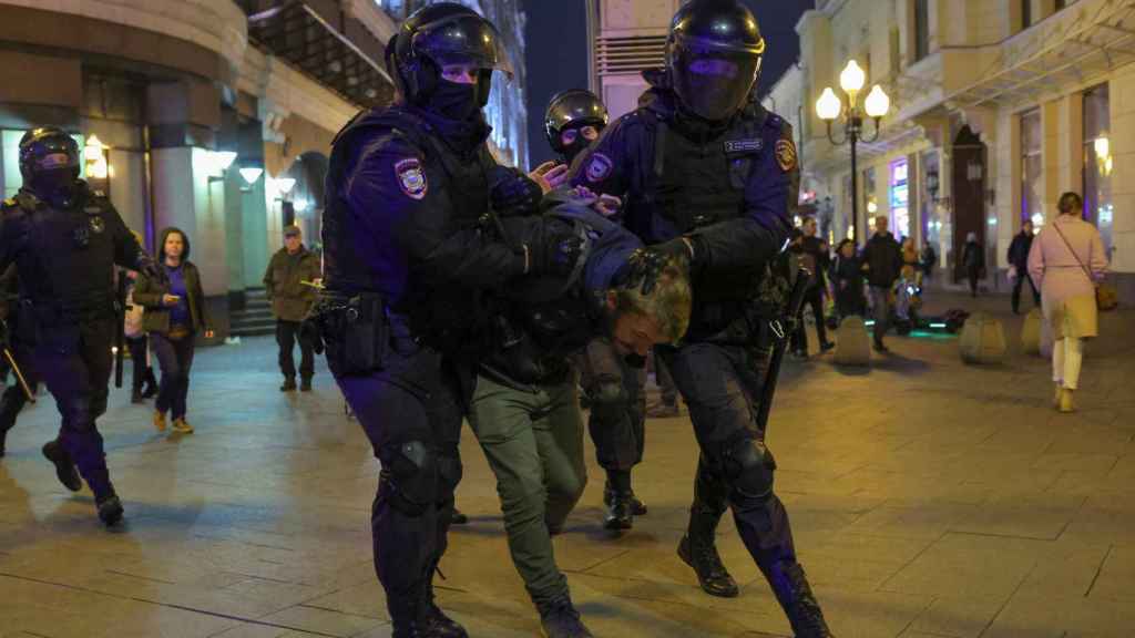 Russia n police officers detain a man during an unauthorized demonstration in Moscow