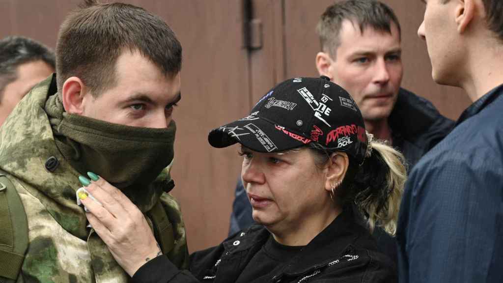 A woman reacts as she says goodbye to a reservist recruited during a partial mobilization.