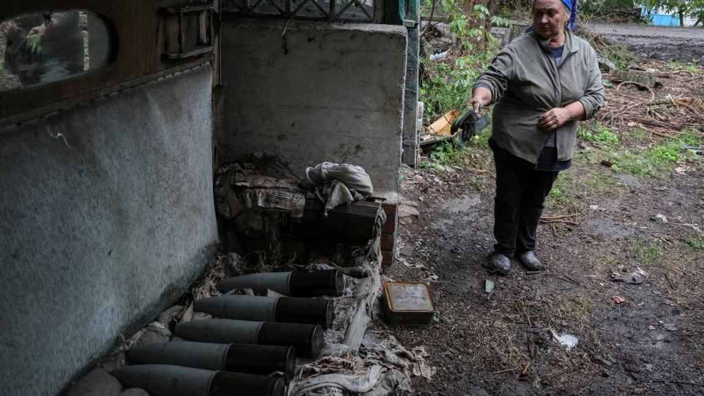 A woman points to the missiles that have destroyed her house in Kharkov.