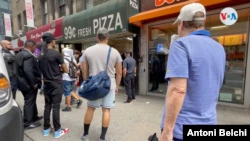 Several people wait in line in front of a pizza stand in Manhattan, New York.  Photo: Antoni Belchi / VOA