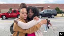 Janay Douglas, left, and Renada Bridgett, right, outside Central Visual and Performing Arts High School in St. Louis, where the shooting occurred on Monday, Oct. 24, 2022.