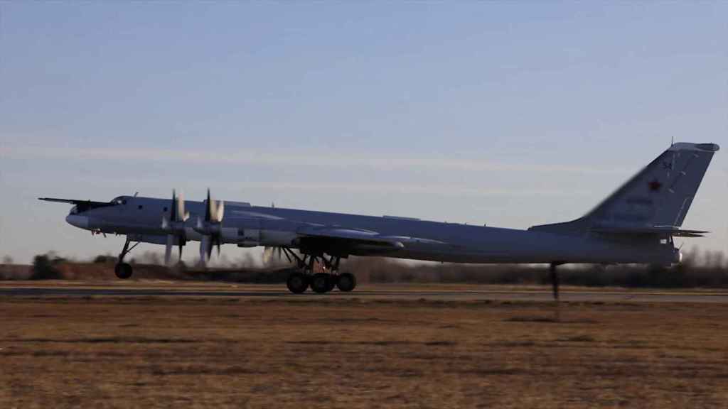 A Tu-95MS strategic bomber takes off in an unknown location.