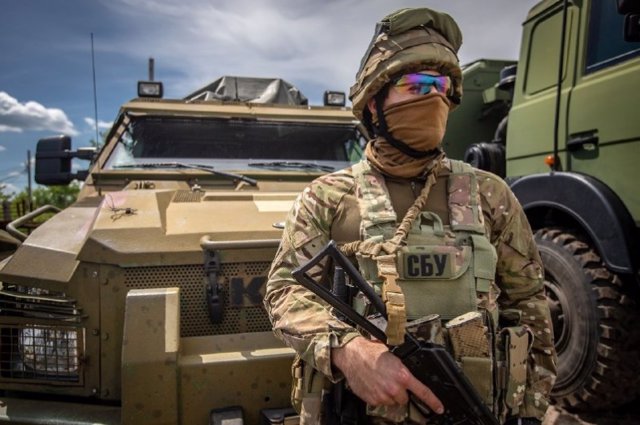 A Ukrainian soldier in front of an armored vehicle