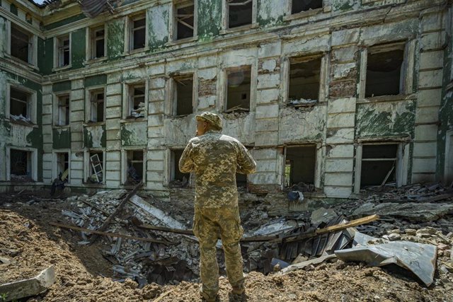 Archive - A Ukrainian soldier before a crater from the impact of a Russian shell.