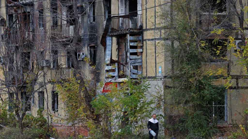 A man walks past a collapsed building in Mariupol.