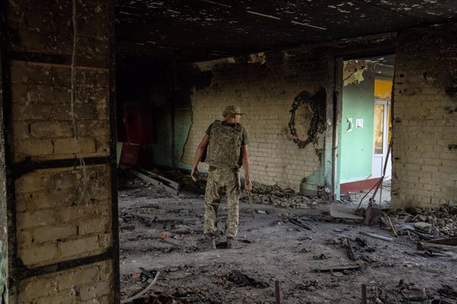 File - A Ukrainian soldier walks through the ruins of a building in Kharkov.