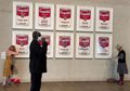 Two activists paint and stick to the frames of 'Campbell's Soup I' paintings at the National Gallery of Australia