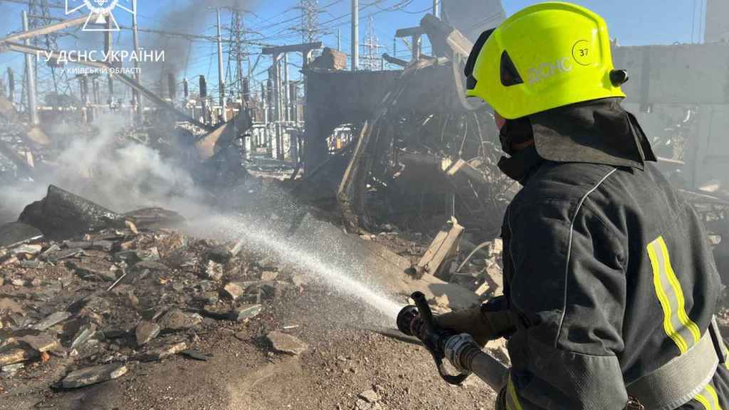 Firefighters work to put out a fire at energy infrastructure facilities, damaged by a Russian missile attack in Ukraine's kyiv region.