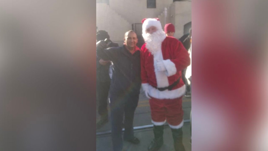 Geovanny Caripaz, 39, takes a photo with Santa Claus on Christmas Day at a migrant shelter in El Paso, Texas.  (Courtesy: Geovanny Caripaz)