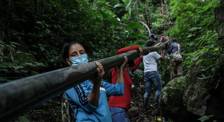 Yarledys Olaya (left), an indigenous Barí who was a member of the now-defunct FARC guerrilla for 20 years, works with other ex-combatants and local residents to build a water pipeline.