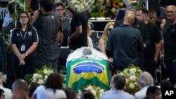 The coffin with the remains of Brazilian soccer great Pele lies in state during his wake on the pitch of the Vila Belmiro stadium in Santos, Brazil, Monday, Jan. 2, 2023. (AP Photo/Andre Penner)