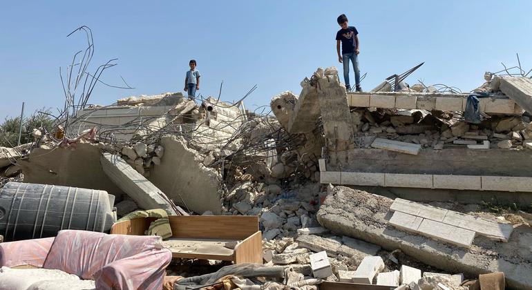 Children stand by a demolished house in Beit Sira, a Palestinian town in the central West Bank.