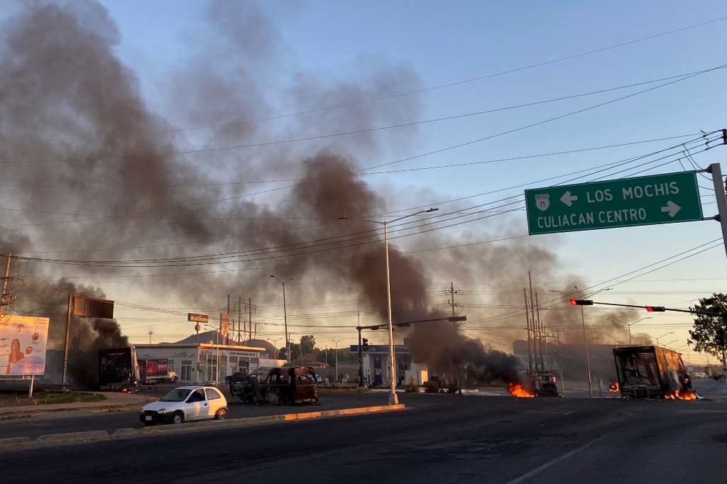 Vehicles on fire are found across the street in the middle of the violent day after the arrest of Ovidio Guzmán.  (Credit: MARCOS VIZCARRA/AFP via Getty Images)