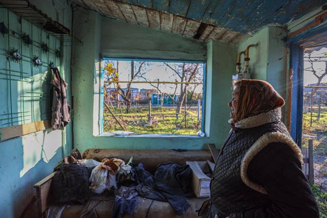 File - Anna, a 67-year-old Ukrainian woman, reacts as she examines her house damaged by Russian artillery fire in a village in the Kherson region of Ukraine.