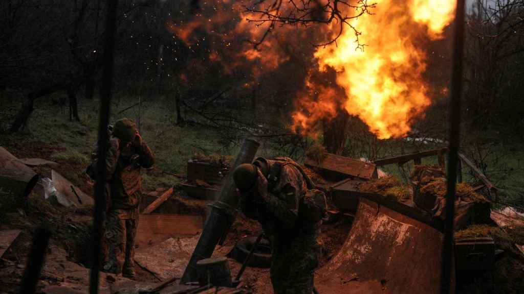 Ukrainian soldiers fire a mortar at the front line.