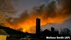 In this photo provided by Melissa Smith, a burning train is seen from her farm in East Palestine, Ohio, on February 3, 2023.