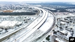 An icy mix blankets the 114 Freeway on Monday, January 30, 2023 in Roanoke, Texas.  Dallas and other parts of North Texas are under a winter storm warning through Wednesday.  (Lola Gomez/The Dallas Morning News via AP)