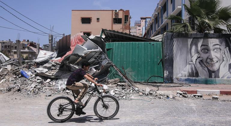 A boy rides a bicycle near some buildings destroyed by Israeli attacks in the Gaza Strip, Palestine