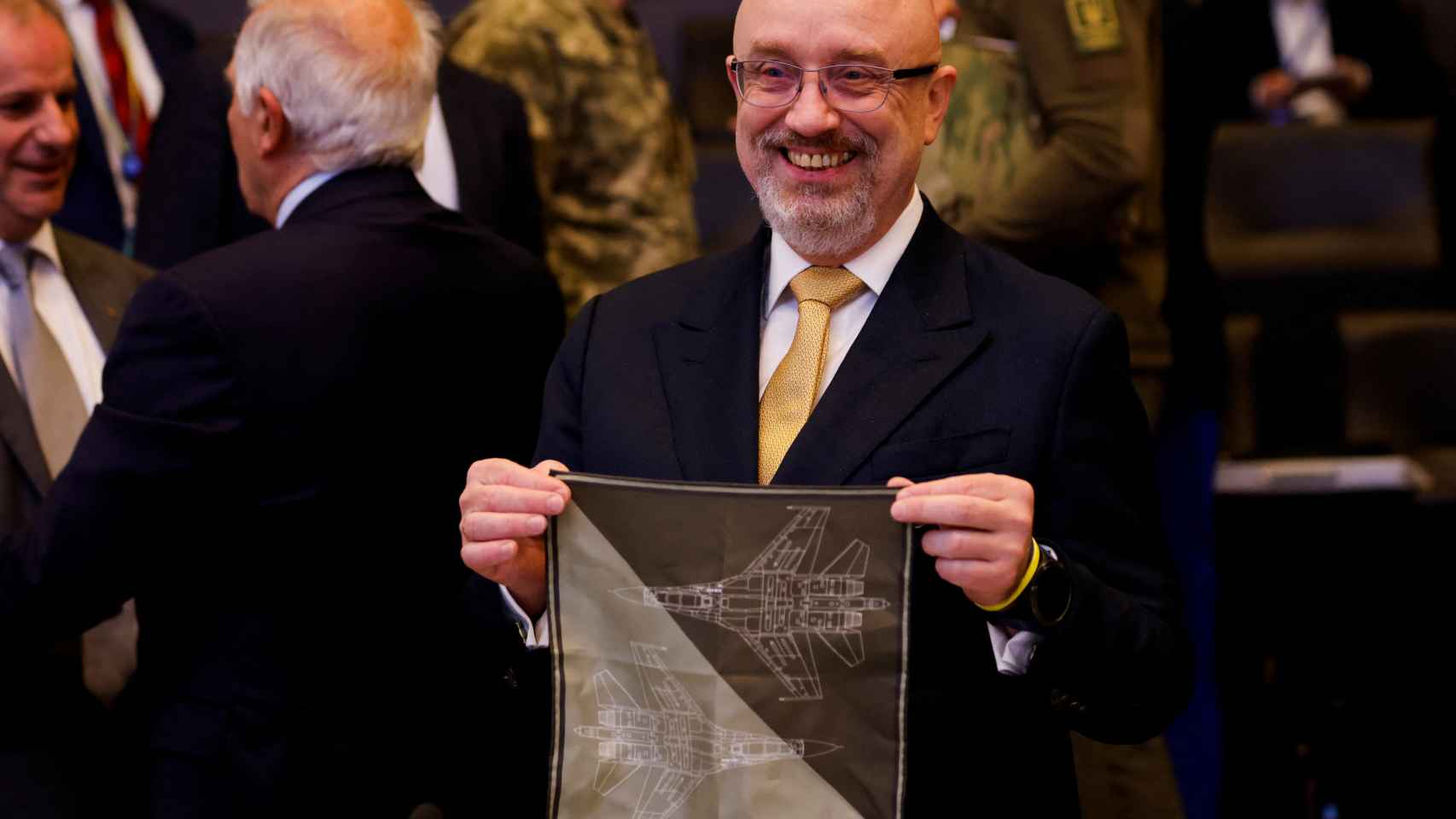 Ukraine's Defense Minister Oleksii Reznikov displays a scarf with fighter drawings during the NATO meeting in Brussels