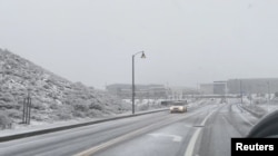 Vehicles travel through snow on freeways in Castaic, Los Angeles County, on February 25, 2023.