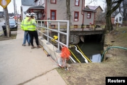 FILE - Members of the US Environmental Protection Agency (EPA) inspect the site of a hazardous material train derailment in East Palestine, Ohio, on February 16, 2023.