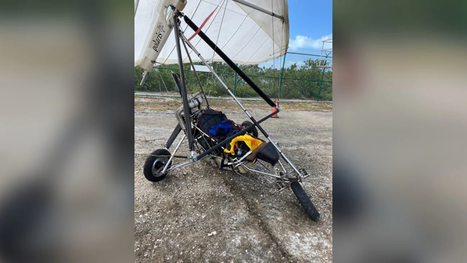 Cuban migrants arrive at the Key West airport on a motorized hang glider