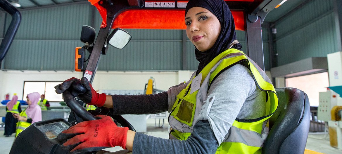 A woman drives a forklift at the recycling plant where she works, in North Shouneh, Jordan.