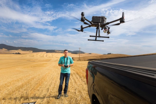 Image of the farmer Nelson directing a drone that flies over his crops.