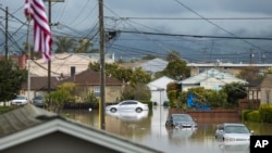 Cars partially submerged in floodwaters in Watsonville, Calif., on Saturday, March 11, 2023. (AP Photo/Nic Coury)