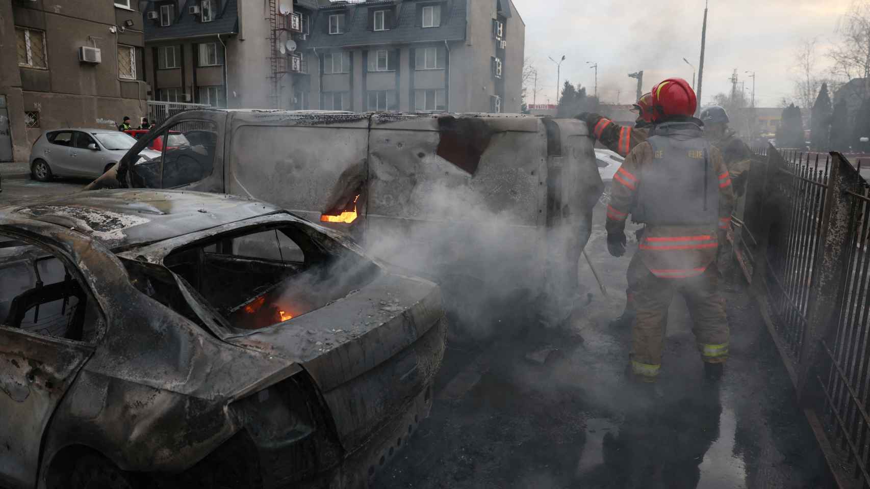 Local residents stand near the remains of residential buildings destroyed by a Russian missile attack, amid Russia's attack on Ukraine, near the city of Zolochiv, Lviv region.