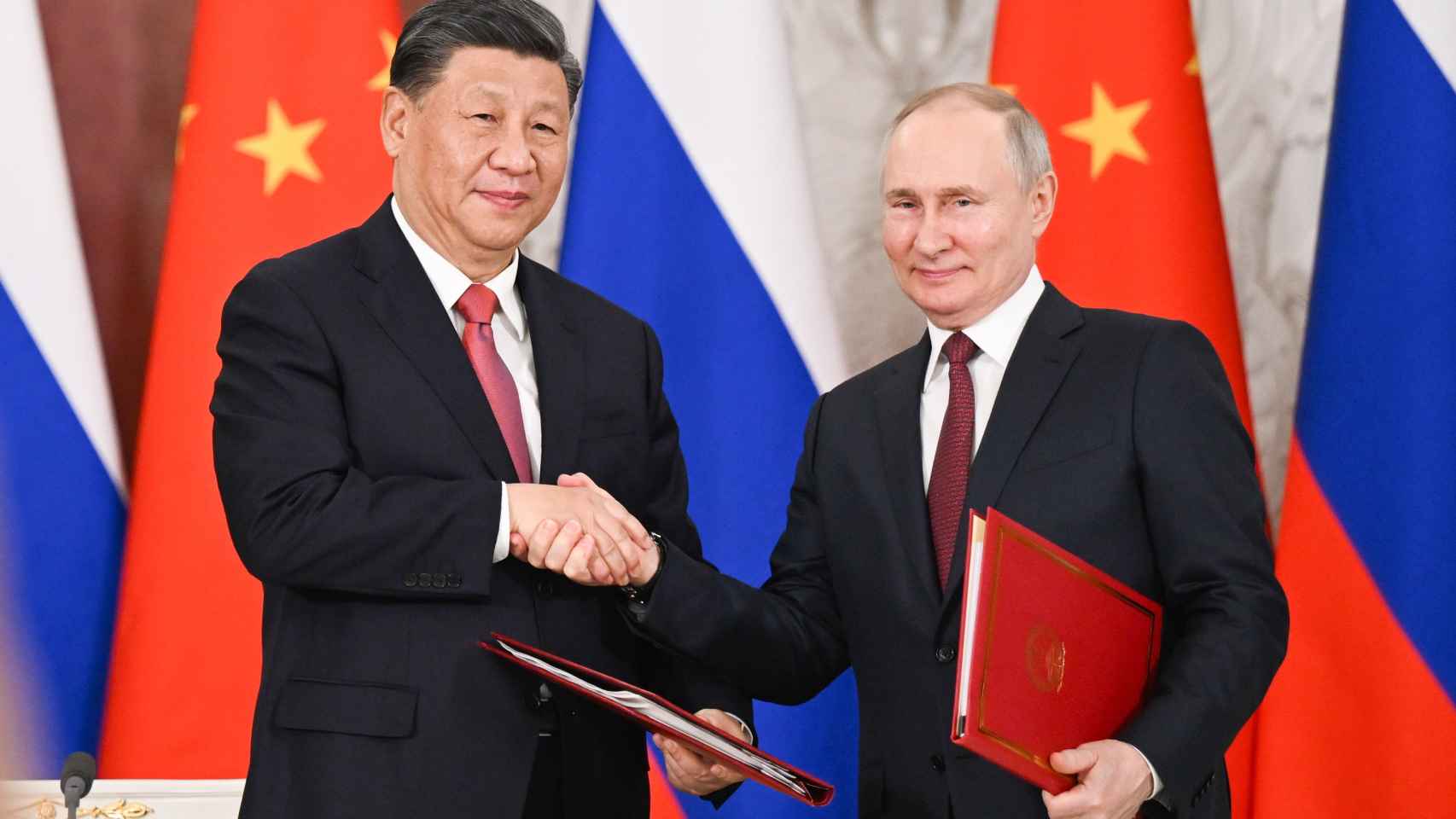 Chinese and Russian Presidents Xi Jinping and Vladimir Putin shake hands during their recent meeting in Moscow.