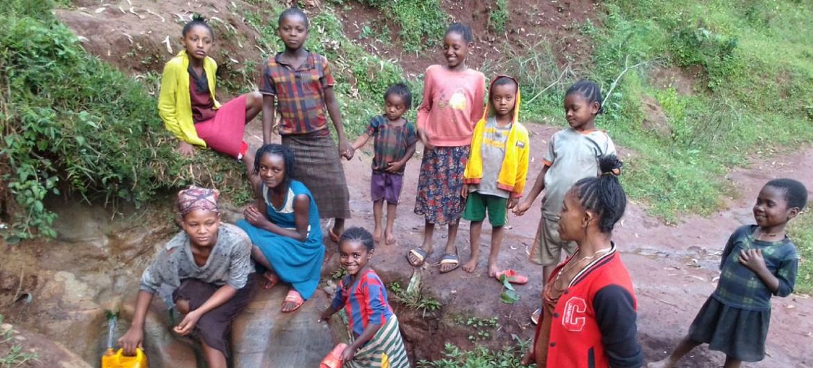 Ethiopian families collecting water from a makeshift stream.